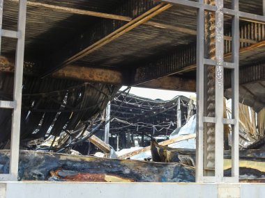 Yapısal çelik çerçeve içindeki bir manzara yangının tahrip ettiği bir binanın iç kısımlarını aydınlatıyor..