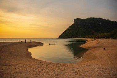 Kadınlar akşamları kumsalda yürüyüp dinlenirler..