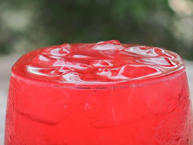 Bardakta soğuk kırmızı tatlı içecek.