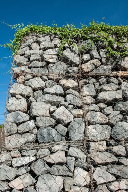 Dalgaların aşınmasını önlemek için kayaları doldurun..