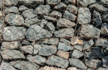 Dalgaların aşınmasını önlemek için kayaları doldurun..