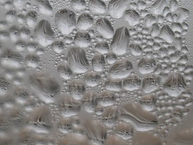 Gümüş-bronz bardakta buz damlaları.