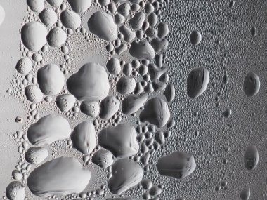 Gümüş-bronz bardakta buz damlaları.