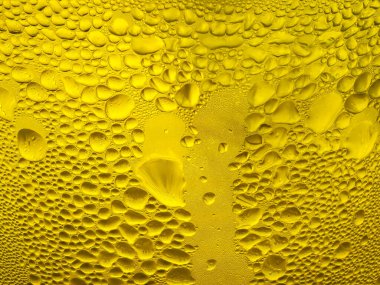 Sarı bir bardağa buz damlaları