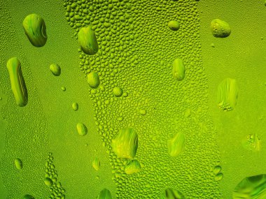 Yeşil bir bardağa buz damlaları