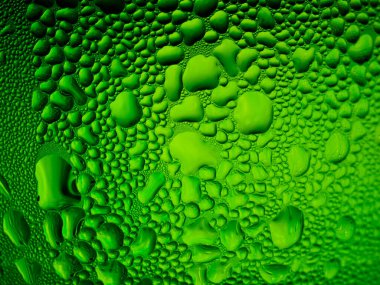 Yeşil bir bardağa buz damlaları