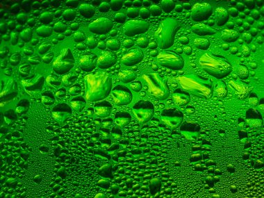 Yeşil bir bardağa buz damlaları