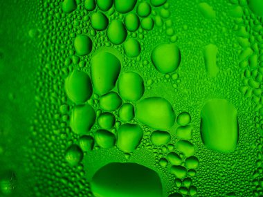 Yeşil bir bardağa buz damlaları