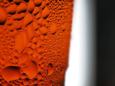 Sarı-turuncu bardakta buz damlaları