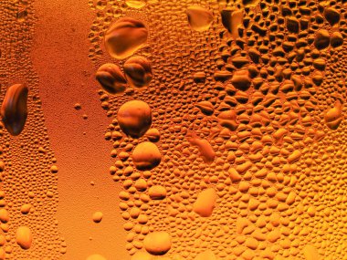 Sarı-turuncu bardakta buz damlaları