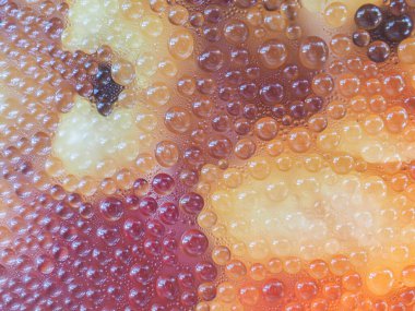 Uzun saçlı siyah kadın kolye takıyor.