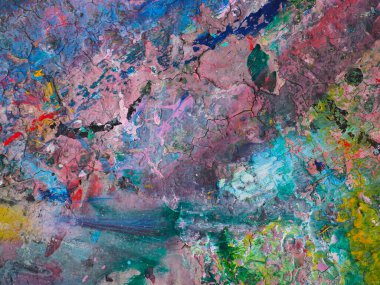 Masaya sürülmüş boyanın renkli desenleri var.