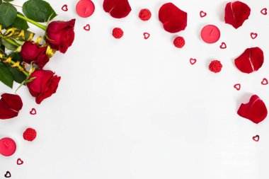 Composition of red roses, rose petals, sequin hearts, candles, gold ribbons on white background. Content for Birthday, Valentines Day, Womens day, Mothers day. Flat lay, top view, close up, copy space
