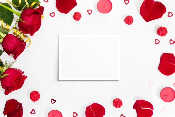 Composition of red roses, rose petals, sequin hearts, candles, gold ribbons, blank card on white background. Content for Birthday, Valentines Day, Mothers day. Flat lay, top view, close up, copy space
