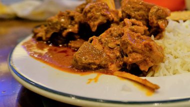 Closeup of Spicy Rogan josh mutton or goat curry with aromatic Basmati rice or Chawal
