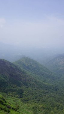 Sis ve bulutlu gökyüzü ile dolu güzel, gür, yeşil kodaikanal tepe manzaraları. Tepeden manzara görünümü.