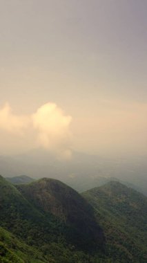 Gün batımında ya da gün doğumunda sis ve bulutlu gökyüzü ile dolu güzel, yoğun, yeşil Kodaikanal tepe manzaraları. Altın saat boyunca tepeden manzara.
