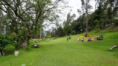 Kodaikanal, Hindistan - 02 Temmuz 2023: Chettiar Park 'ın güzel manzaralı bahçesinin tadını çıkaran turistler.