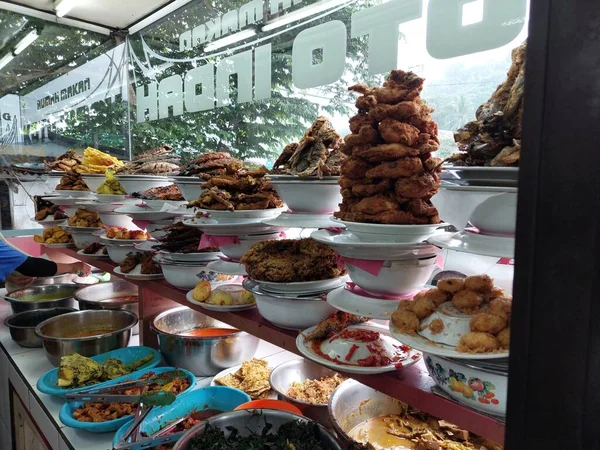 stock image Masakan Padang menu of restaurant. Popular dishes from a Padang eatery, served on layers of plate stacks.