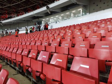Arenanın tribünlerinde ya da konser salonundaki boş koltuklar. Seyirciler olmadan kırmızı ve beyaz stadyum koltukları. Spor ve kitlesel eğlence etkinliklerinin kaldırılması kavramı