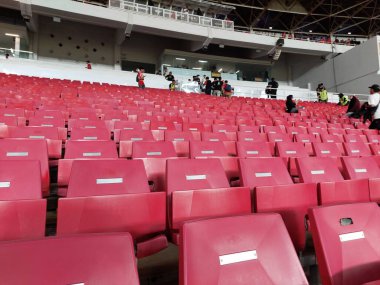 Arenanın tribünlerinde ya da konser salonundaki boş koltuklar. Seyirciler olmadan kırmızı ve beyaz stadyum koltukları. Spor ve kitlesel eğlence etkinliklerinin kaldırılması kavramı