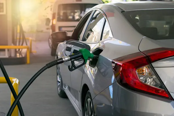 Refuel cars at the fuel pump. The driver hands, refuel and pump the car\'s gasoline with fuel at the petrol station. Car refueling at a gas station.
