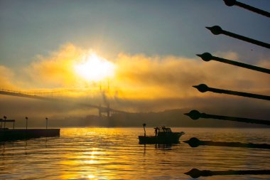 Boğaz 'daki siste bir tekne hareket ediyor. 15 Temmuz Şehitler Köprüsü ve Ortakoy Camii siste.
