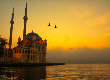 15 Temmuz Şehitler Köprüsü (Boğaz Köprüsü), sis bulutlarında martı ve gün doğumuyla birlikte görülüyor. Ortakoy Camii ve Boğaz Köprüsü 'nden sisli sabah manzarası