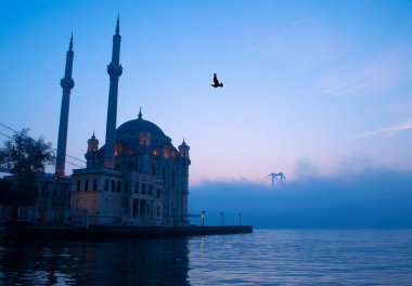 15 Temmuz Şehitler Köprüsü (Boğaz Köprüsü), sis bulutlarında martı ve gün doğumuyla birlikte görülüyor. Ortakoy Camii ve Boğaz Köprüsü 'nden sisli sabah manzarası