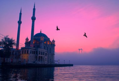 15 Temmuz Şehitler Köprüsü (Boğaz Köprüsü), sis bulutlarında martı ve gün doğumuyla birlikte görülüyor. Ortakoy Camii ve Boğaz Köprüsü 'nden sisli sabah manzarası