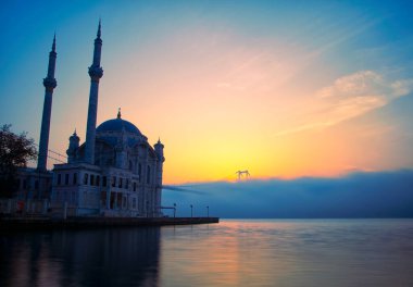 15 Temmuz Şehitler Köprüsü (Boğaz Köprüsü), sis bulutlarında martı ve gün doğumuyla birlikte görülüyor. Ortakoy Camii ve Boğaz Köprüsü 'nden sisli sabah manzarası