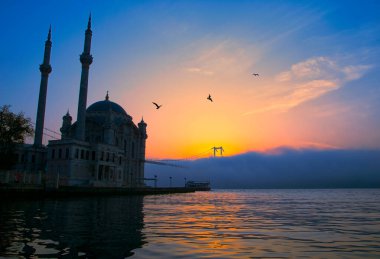 15 Temmuz Şehitler Köprüsü (Boğaz Köprüsü), sis bulutlarında martı ve gün doğumuyla birlikte görülüyor. Ortakoy Camii ve Boğaz Köprüsü 'nden sisli sabah manzarası