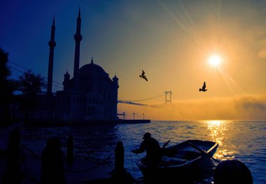 Boğaz Köprüsü 'nün sisli ve puslu sahnesi. İstanbul 'daki Boğaz Köprüsü. İstanbul 'un Asya kesiminden görüntü. Boğaz 'da sisli bir günde balıkçıların siluetleri..