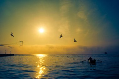 Boğaz Köprüsü 'nün sisli ve puslu sahnesi. İstanbul 'daki Boğaz Köprüsü. İstanbul 'un Asya kesiminden görüntü. Boğaz 'da sisli bir günde balıkçıların siluetleri..