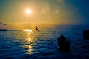 Boğaz Köprüsü 'nün sisli ve puslu sahnesi. İstanbul 'daki Boğaz Köprüsü. İstanbul 'un Asya kesiminden görüntü. Boğaz 'da sisli bir günde balıkçıların siluetleri..