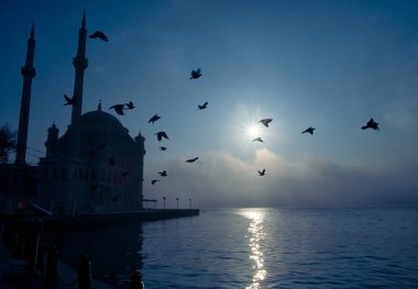 15 Temmuz Şehitler Köprüsü (Boğaz Köprüsü), sis bulutlarında martı ve gün doğumuyla birlikte görülüyor. Ortakoy Camii 'nden sisli sabah manzarası ve 15 Şehitler Köprüsü.