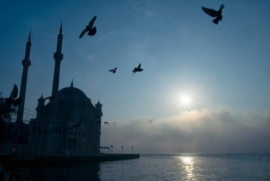 15 Temmuz Şehitler Köprüsü (Boğaz Köprüsü), sis bulutlarında martı ve gün doğumuyla birlikte görülüyor. Ortakoy Camii 'nden sisli sabah manzarası ve 15 Şehitler Köprüsü.