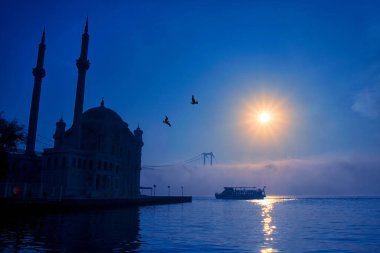 15 Temmuz Şehitler Köprüsü (Boğaz Köprüsü), sis bulutlarında martı ve gün doğumuyla birlikte görülüyor. Ortakoy Camii 'nden sisli sabah manzarası ve 15 Şehitler Köprüsü. 
