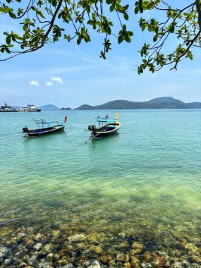 Phuket, Tayland 'daki Panwa Sahili' nden güzel bir deniz manzarası. Görüntü sakin turkuaz sular, yumuşak kumlu kıyılar ve sakin tropikal bir atmosferle huzurlu kıyı manzarasını yakalar.