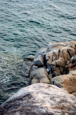 Phuket, Tayland 'da okyanusun üzerinde güzel bir gün batımı, durgun suya yansıyan renkli gökyüzü. Canlı turuncu ve pembe renkleri olan tropik bir cennet. Seyahat ve tatil temaları için mükemmel..