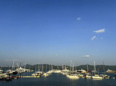 Yacht Haven Marina, Phuket, Tayland 'daki Tranquil Bay' de demirli yelkenliler ve motorlu tekneler.