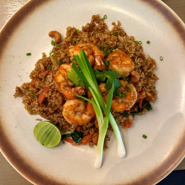 Lezzetli Asya mutfağında karidesli kızarmış pirinç ve taze otlar.