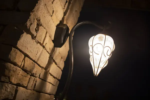 Türkiye 'de karanlıkta tuğla bir duvarda güzel bir antik lamba.