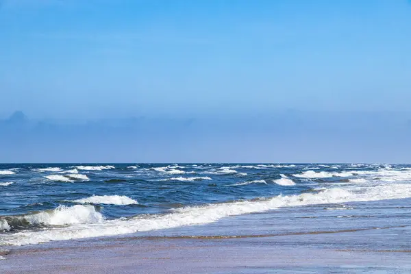Danimarka 'nın Rm adasında dalgaları ve mavi gökyüzü olan güzel deniz.