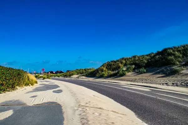 Kum ve kumul manzaralı güzel Romo adası Danimarka 'da güneş ışığı ve mavi gökyüzü.