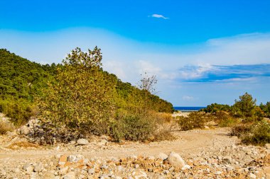 güzel kayalık manzara ve yolun sonunda güzel mavi deniz ve Goynuk Türkiye 'de kara ile deniz arasında bir yol köprüsü (Antalya / Kemer))