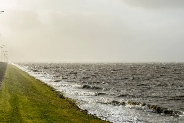 Romo Danimarka 'daki köprüde (Romodaemningen) rüzgarlı ve güneşli günlerde deniz kenarındaki güzel dalgalar