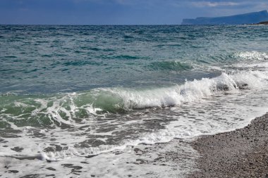 Türkuaz denizli güzel dalgalar ve Kemer Türkiye 'de çok sayıda küçük çakıl taşları