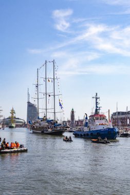 Güzel bir yelkenli, Almanya 'nın Bremerhaven kentindeki 2025 yelkenlisindeki Yeni Liman' a halatla yanaşmak üzere 13 Ağustos 2025 'te bir römorkör tarafından çekilir.