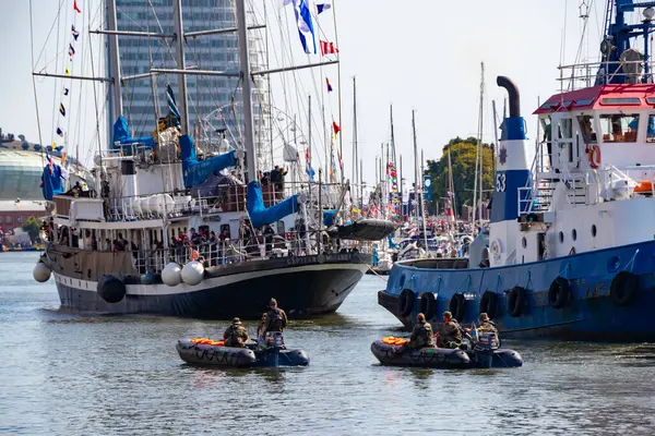 Çok sayıda bayraklı güzel bir yelkenli gemisi, Almanya 'nın Bremerhaven kentindeki 2025 yelkenlisindeki Yeni Liman' a halatla yanaşmak üzere 13 Ağustos 2025 'te bir römorkör tarafından çekilir.